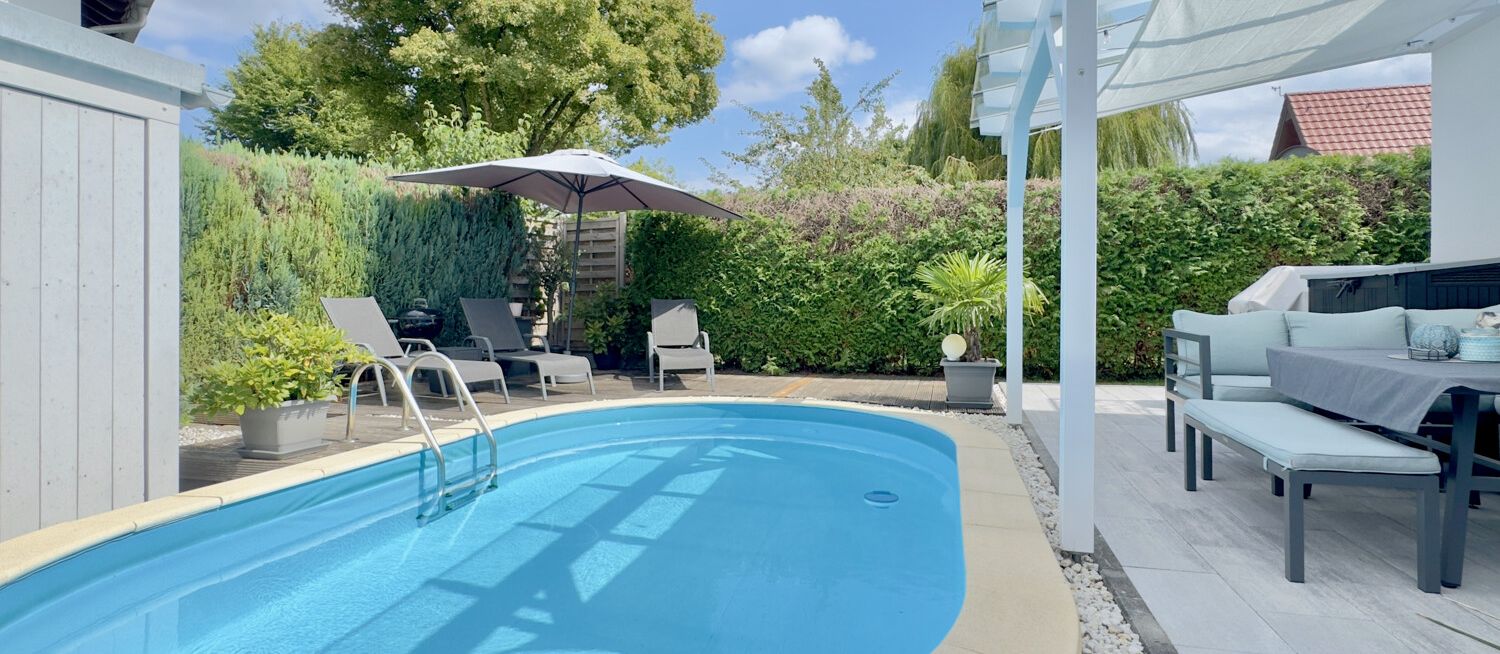 Moderne Poolanlage mit überdachter Terrasse und Liegefläche