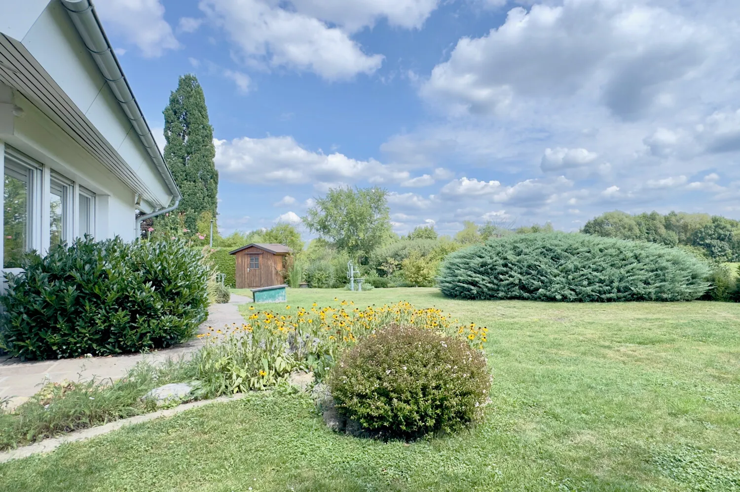 Ebenerdiger Zugang Naturstein-Terrasse zum großzügigen Gartenbereich