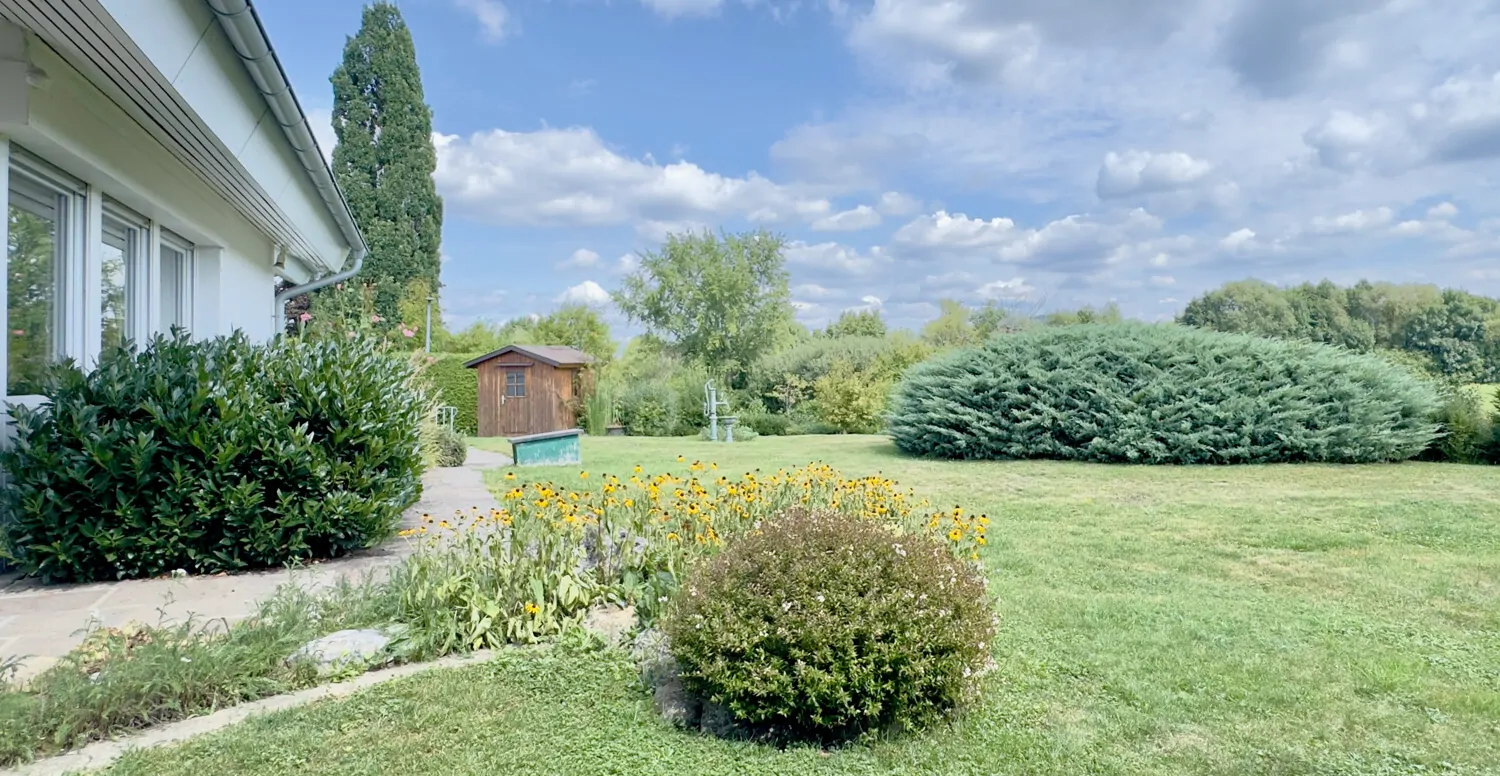 Ebenerdiger Zugang Naturstein-Terrasse zum großzügigen Gartenbereich