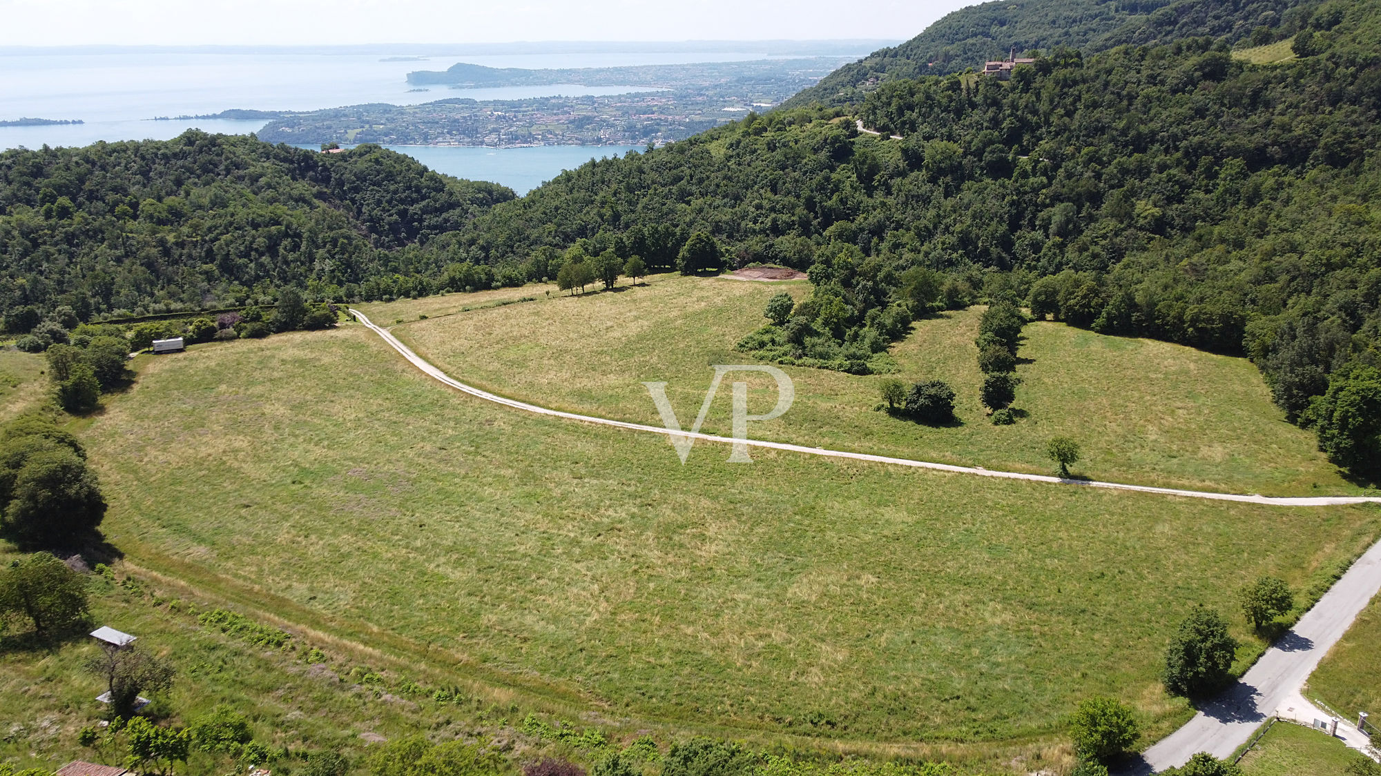 Terreno productivo y bosque con una hermosa vista del lago en Salò