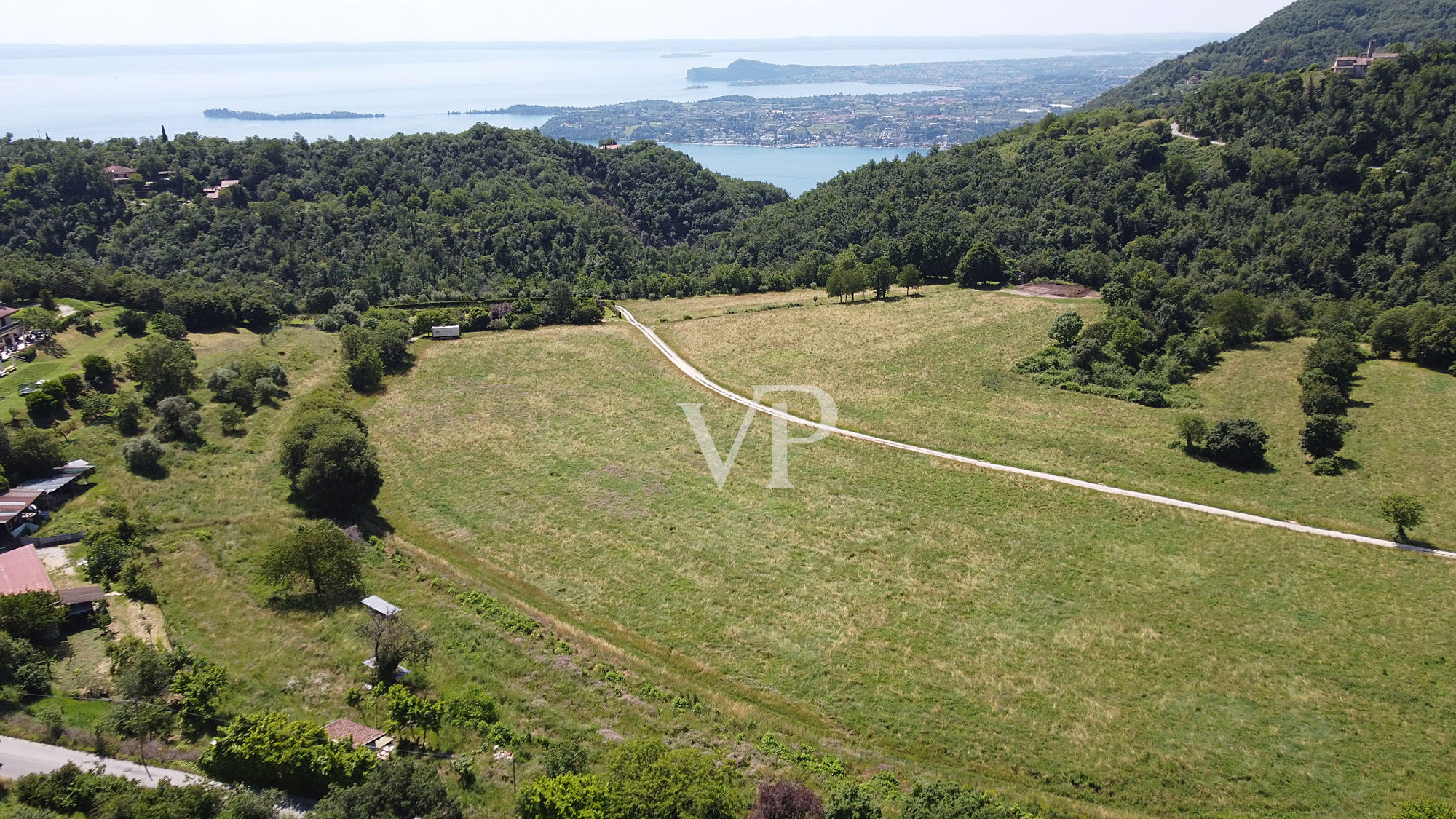 Terreno productivo y bosque con una hermosa vista del lago en Salò