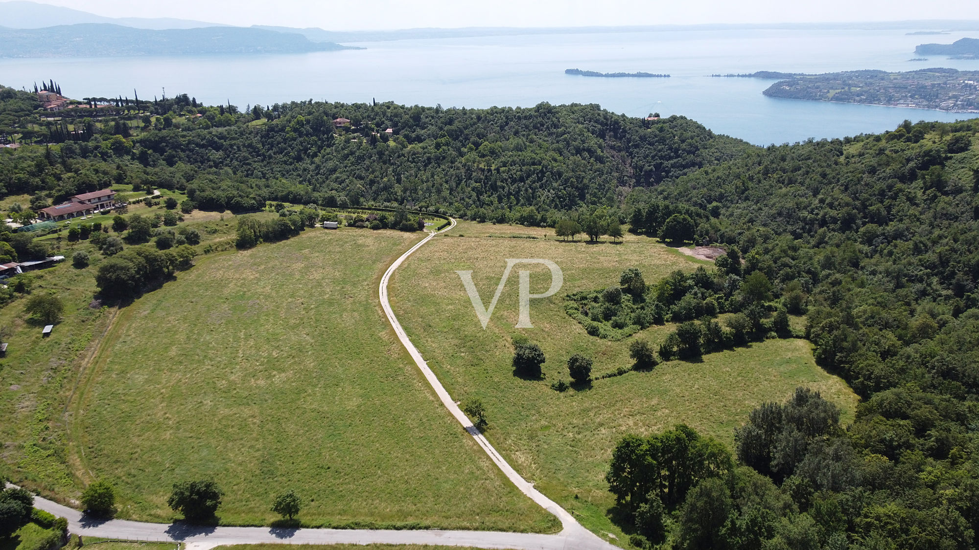 Terreno productivo y bosque con una hermosa vista del lago en Salò