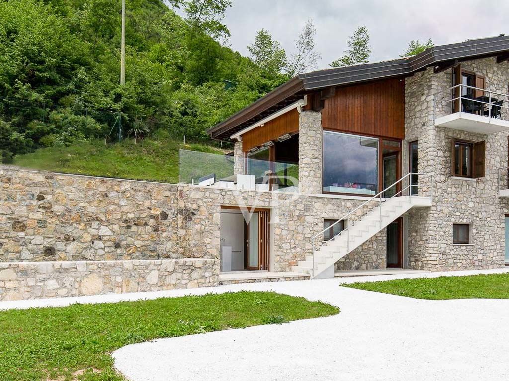 Chalet de montagne luxueux et totalement autosuffisant avec piscine à débordement, situé dans un endroit unique avec vue sur le lac.