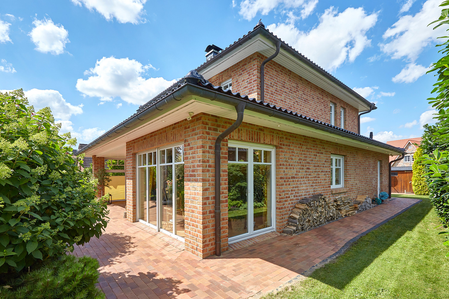 Umlaufende Terrasse zum Carport mit Schuppen