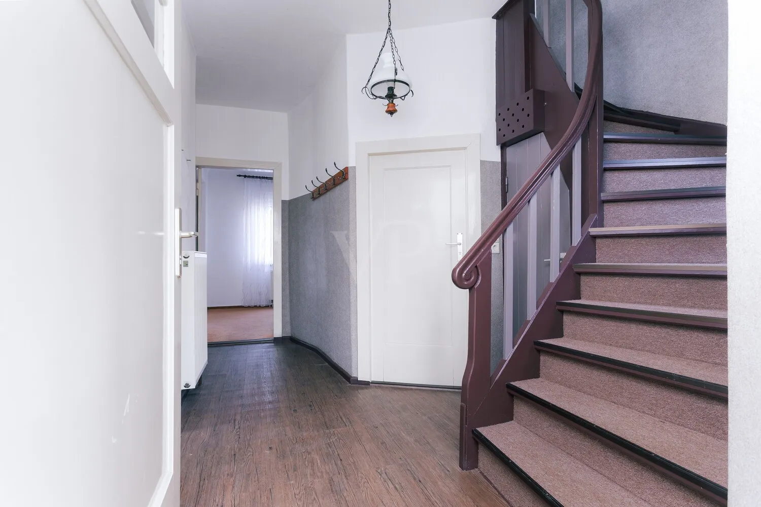 Flur mit Blick auf die originale Holztreppe