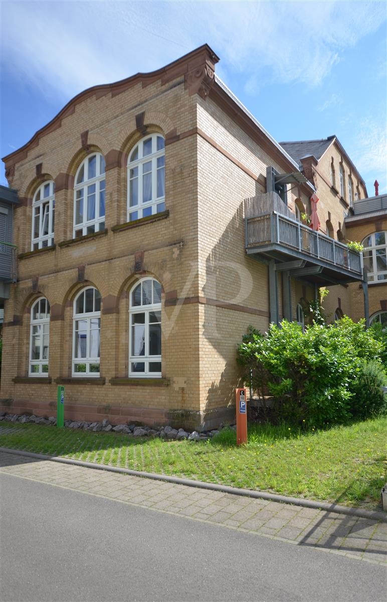 Hausansicht mit Balkon und den zwei Stellplätzen