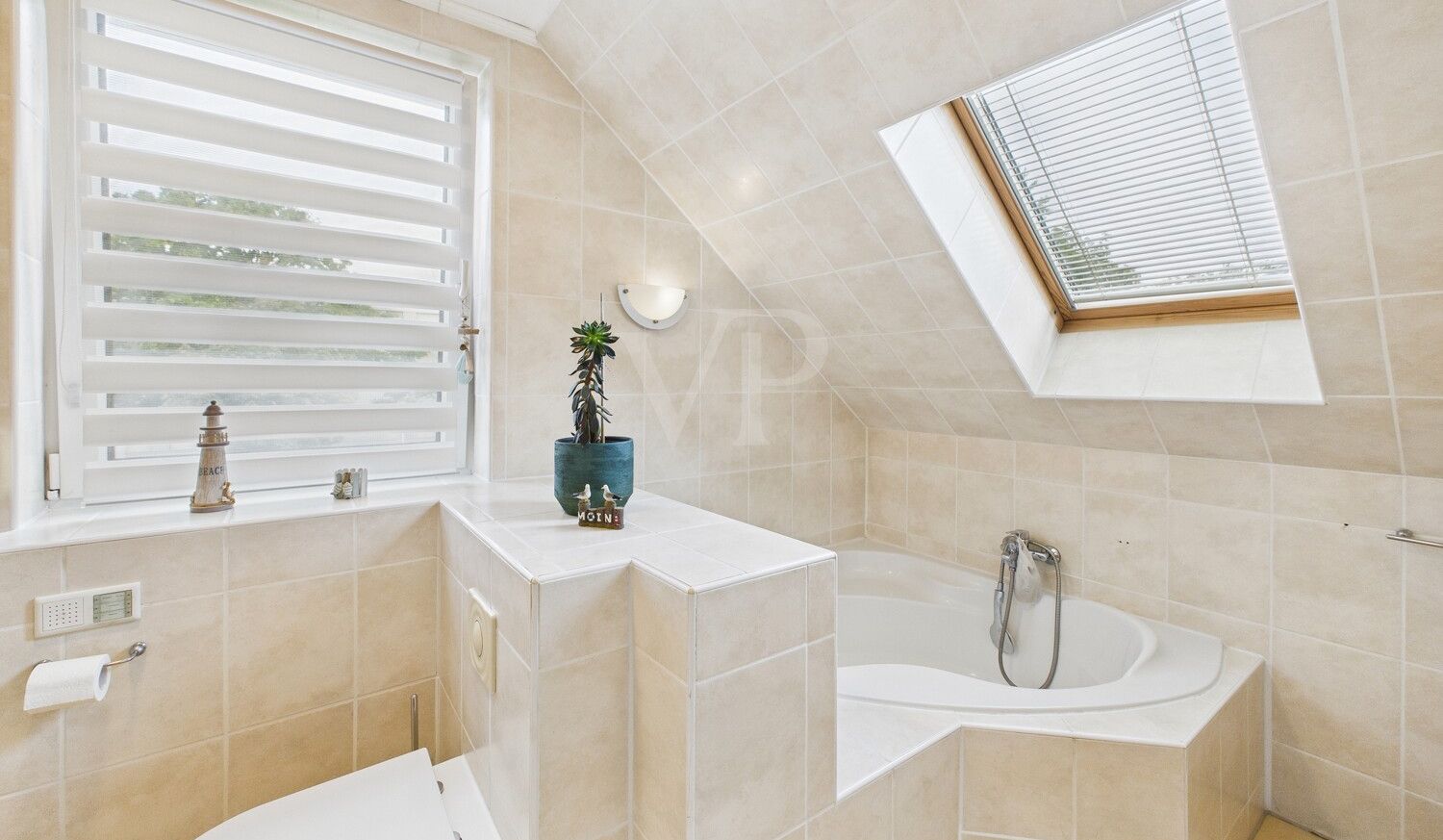 Badezimmer mit Eckbadewanne im Dachgeschoss