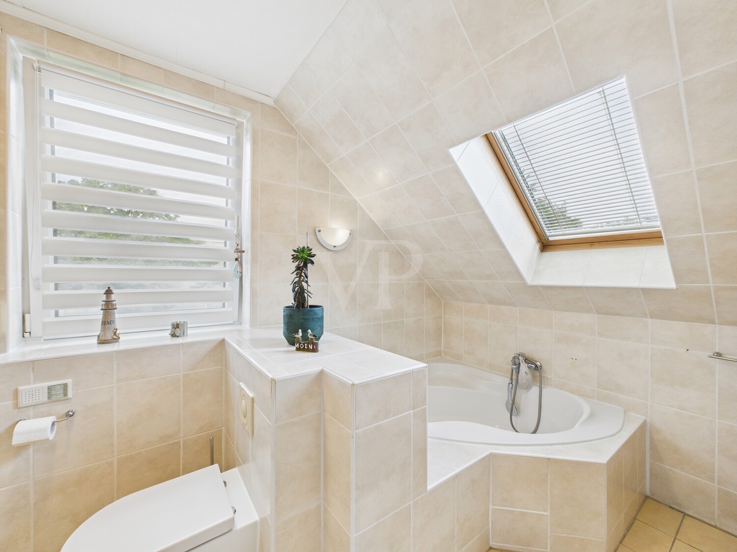 Badezimmer mit Eckbadewanne im Dachgeschoss