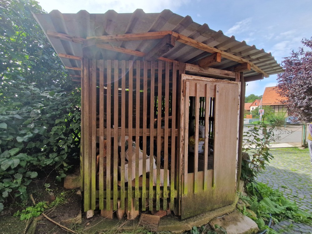 Holzlager und Brunnen