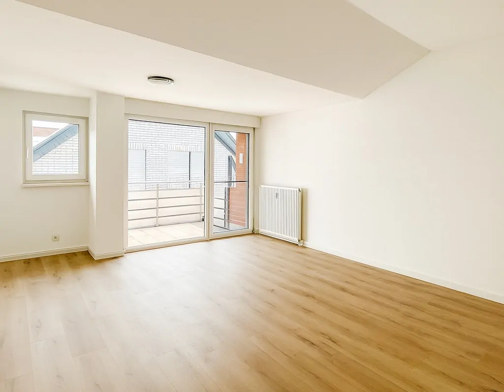 Wohnzimmer mit Balkon und Küche.