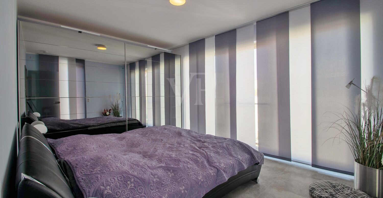 Schlafzimmer mit Fensterfront und Ausgang auf die Terrasse