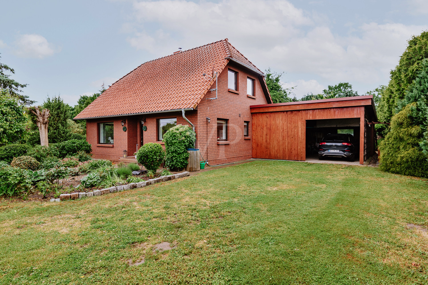 Zweigeteilter Carport: eine Seite für Fahrzeuge, die andere als Holzlager
