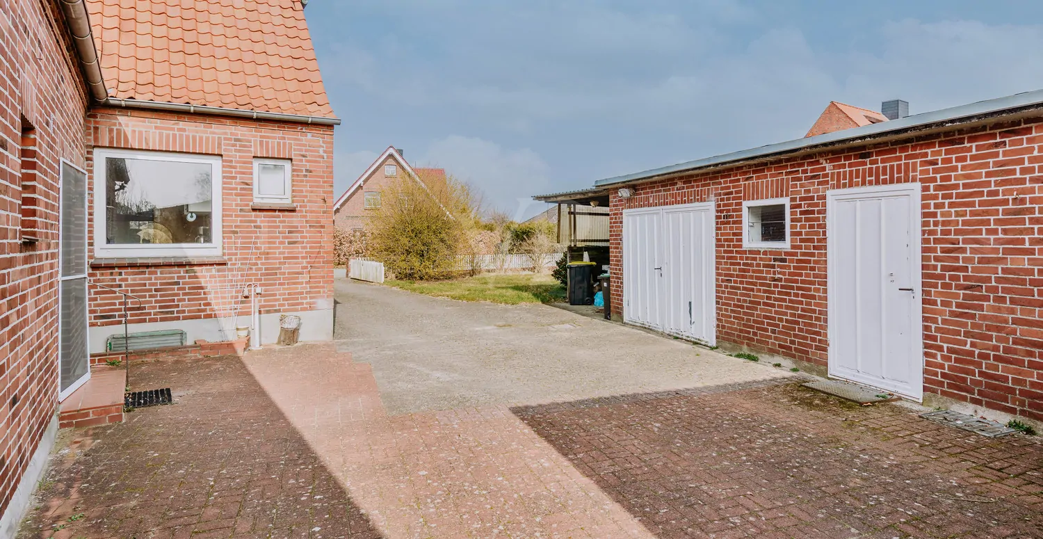 Hofbereich mit Nebeneingang auf beiden Seiten, angrenzend das Nebengebäude mit Garagen.